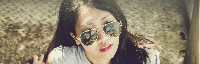 young woman in sunglasses in urban environment
